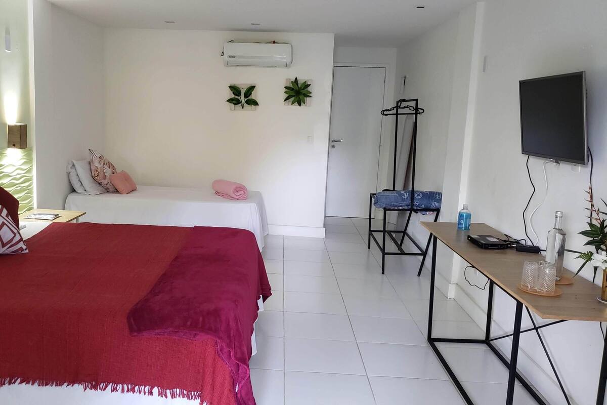 Quarto triplo conforto, vista parcial para o mar | Escrivaninha, espaço de trabalho para notebook, Wi-Fi de cortesia