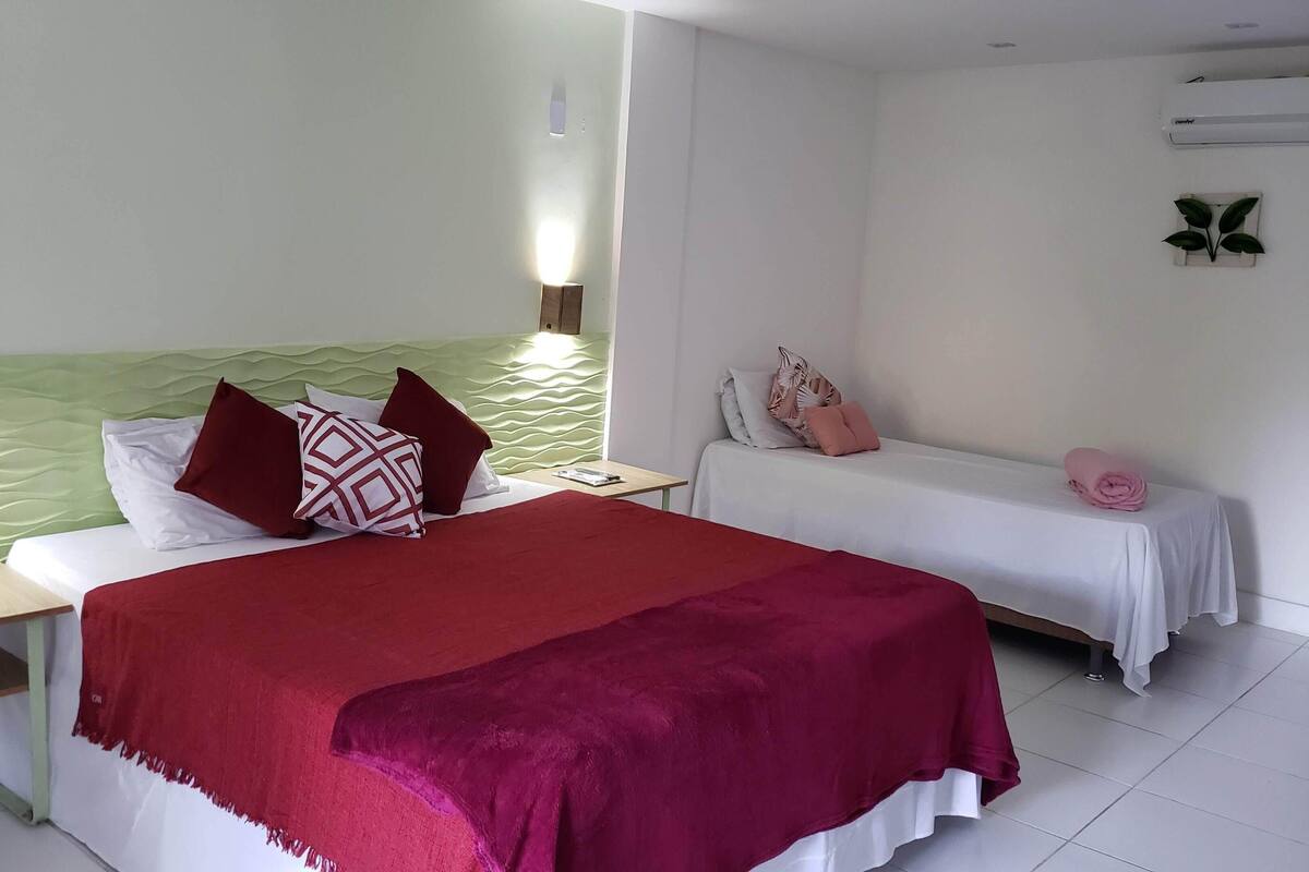Quarto triplo conforto, vista parcial para o mar | Escrivaninha, espaço de trabalho para notebook, Wi-Fi de cortesia