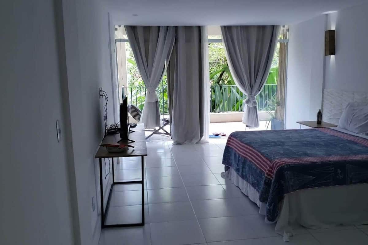 Quarto triplo conforto, vista parcial para o mar | Escrivaninha, espaço de trabalho para notebook, Wi-Fi de cortesia