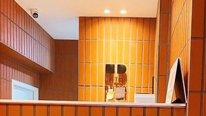 Un espace d’accueil comprenant un comptoir d’enregistrement, un panneau d’affichage fixé au mur et une caméra de surveillance.