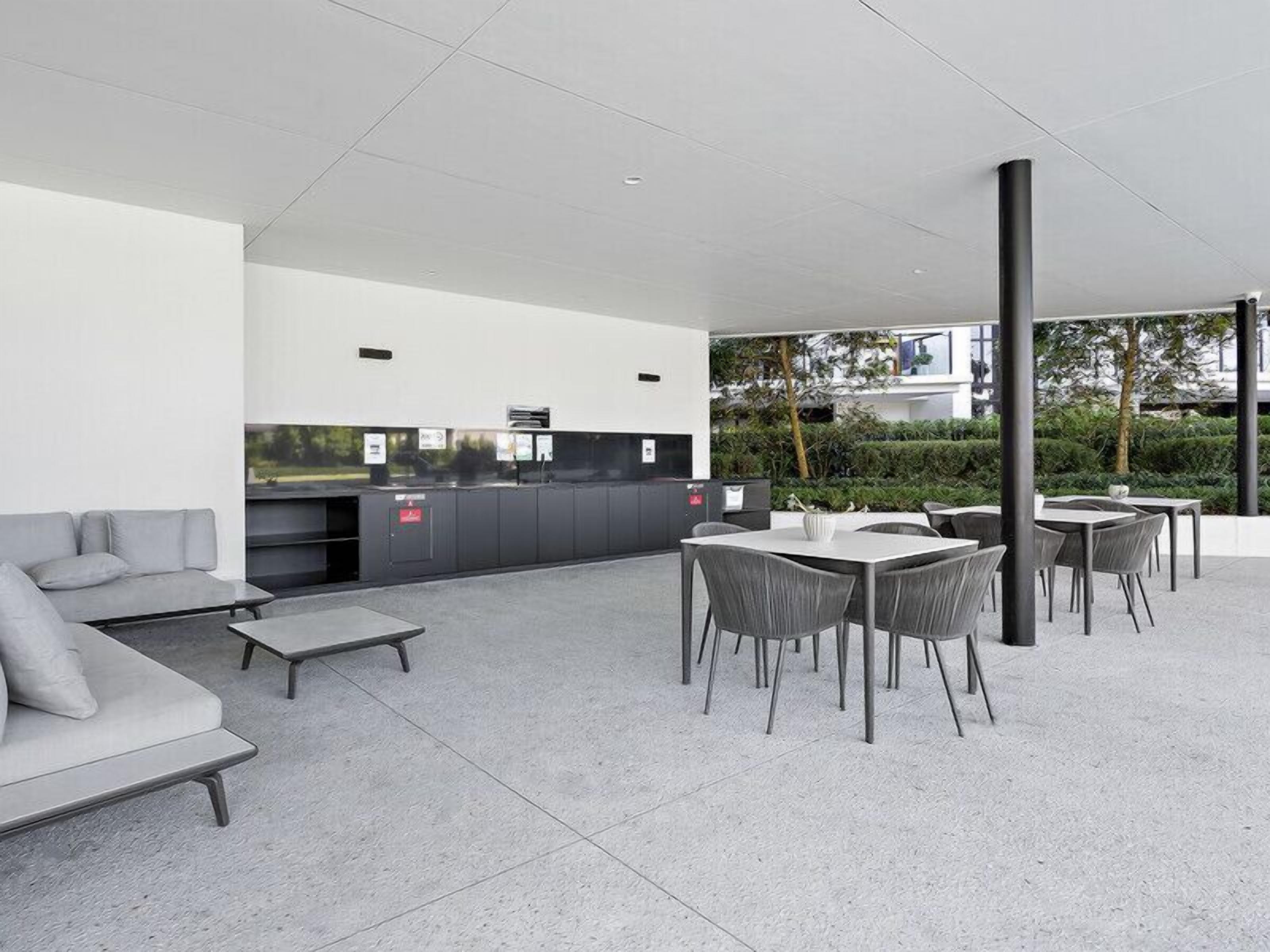A modern outdoor patio area with a sofa, dining tables, and chairs.