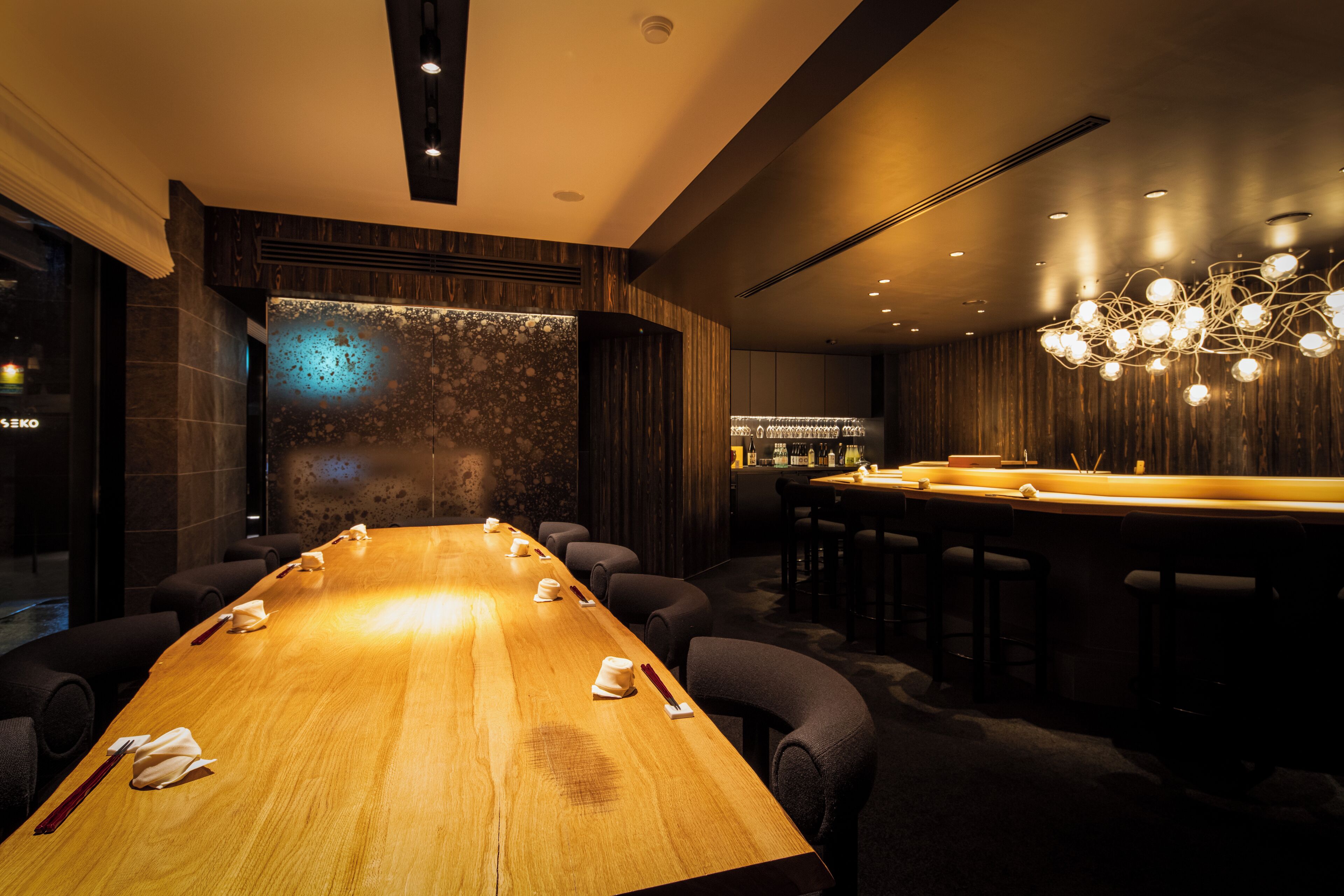 A conference room with a long table, chairs, and a bar area.