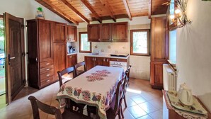 A wooden kitchen with a dining table, cabinets, and a window. - Vacation home Relax by Interhome (Carlazzo)