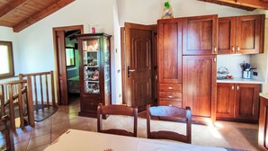A wooden interior with a dining area, a kitchen with wooden cabinets, and a glass display cabinet. - Vacation home Relax by Interhome (Carlazzo)
