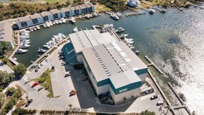 Ein Yachthafen mit einem großen Gebäude, auf dem „MARINA“ steht, und mehreren dort liegenden Booten.