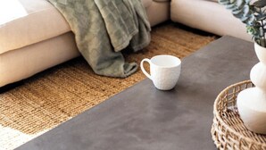 A cozy living room with a beige sofa, a green throw blanket, and a white mug on a dark table. - Casa Blanca - Lakeside Luxury (Mount Warrigal)