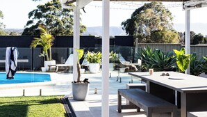 A covered outdoor area with a pool, seating, and potted plants. - Casa Blanca - Lakeside Luxury (Mount Warrigal)