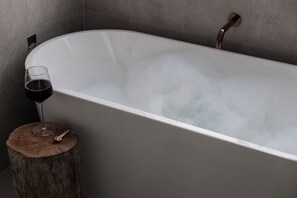 A bathtub with a glass of red wine and a wooden stool beside it. - Casa Blanca - Lakeside Luxury (Mount Warrigal)