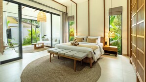 A modern bedroom with a large bed, a bench, and a view of greenery outside.