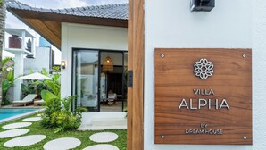 A villa named "Villa Alpha" with a wooden sign, a pool, and a well-maintained garden. - Alpha Villa by DH (Ubud)