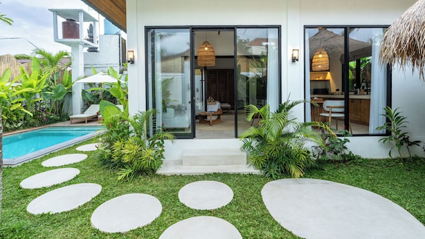 A modern house with a swimming pool, a patio with steps leading to the entrance, and a well-maintained garden. - Alpha Villa by DH (Ubud)