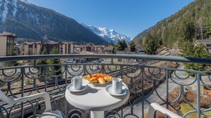 Ein Balkon mit Tisch, zwei Tassen und einer Auswahl an Gebäck.
