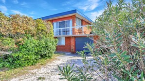 A modern two-story house with a blue roof, large windows, and a visible garage door. - Jimmys Beach Waterfront (Hawks Nest)