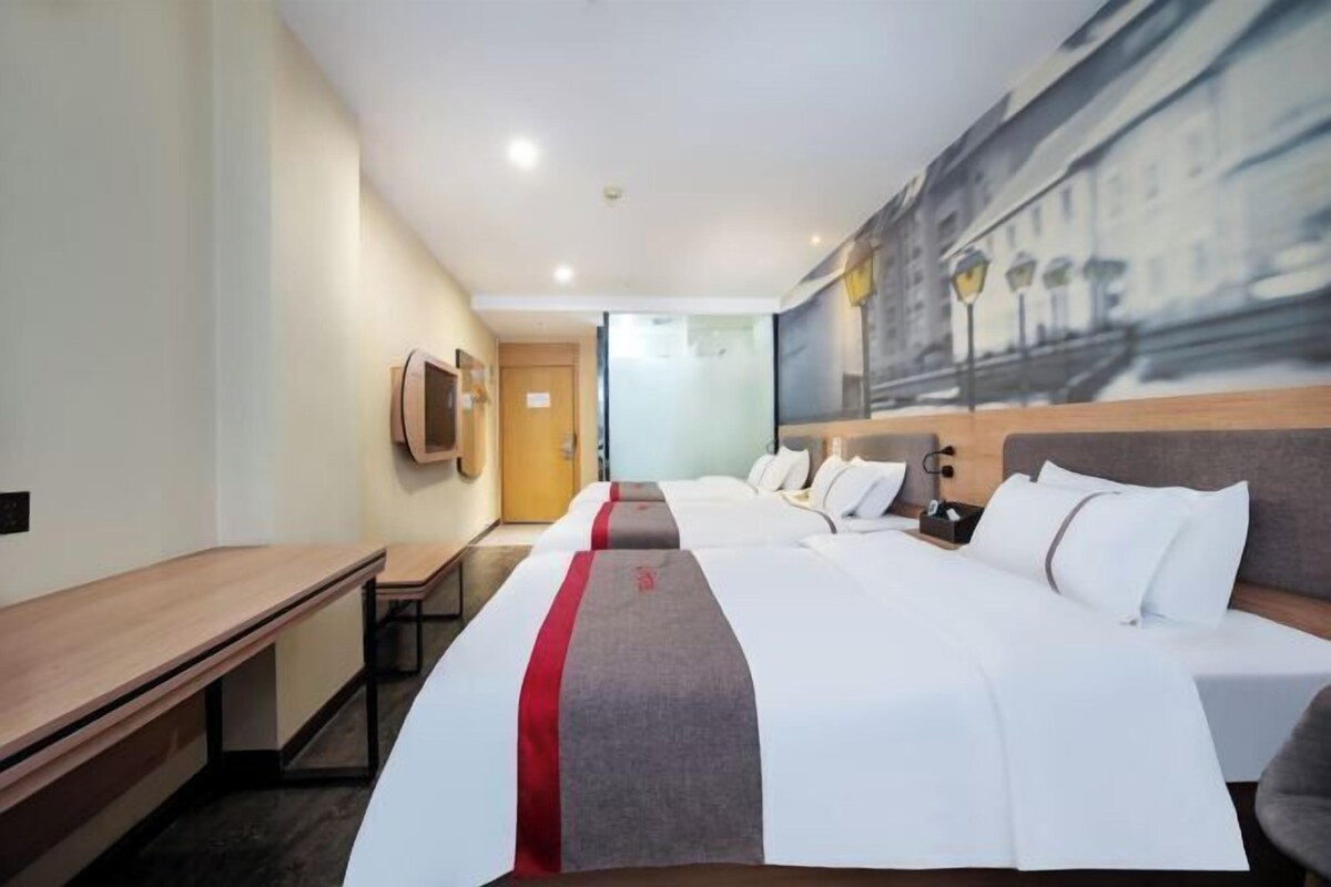 Une chambre d’hôtel avec un grand lit, un bureau et un tableau au mur.