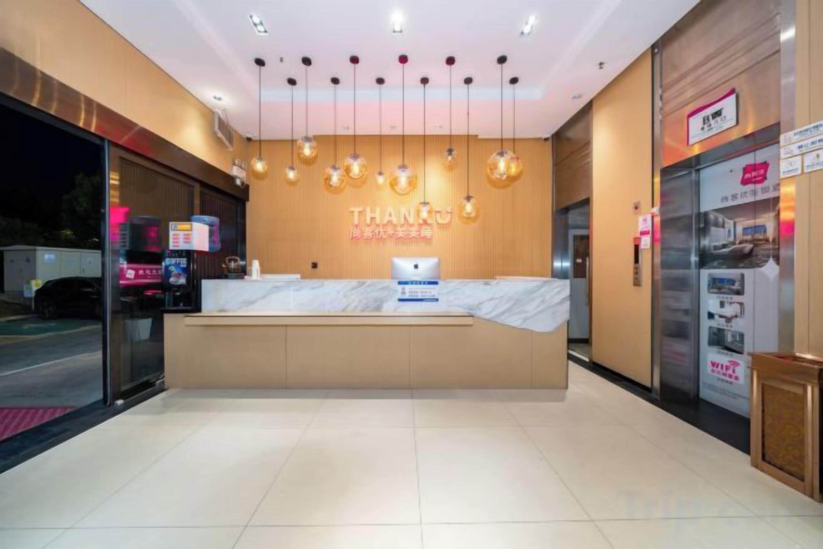 A hotel reception area with a marble counter, a sign reading 'THANKS,' and a vending machine.