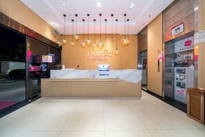 A hotel reception area with a marble counter, a sign reading 'THANKS,' and a vending machine. - Thank Inn Chain Hotel (Zhengzhou Zhongyuan Futa Metro Station) (Zhengzhou)
