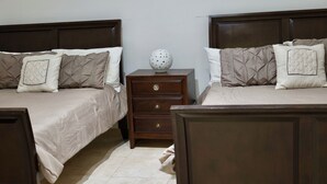 Un dormitorio con dos camas, una mesita de noche y un jarrón decorativo.