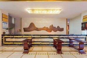 A hotel reception area with a marble counter, a large wall-mounted artwork, and a seating area with benches. - Days Hotel by Wyndham Suixian Shennong (Sui County)