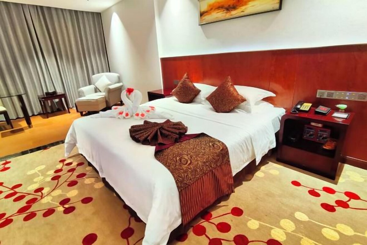 Habitación de hotel con una cama grande, una mesita de noche, una silla y un escritorio.