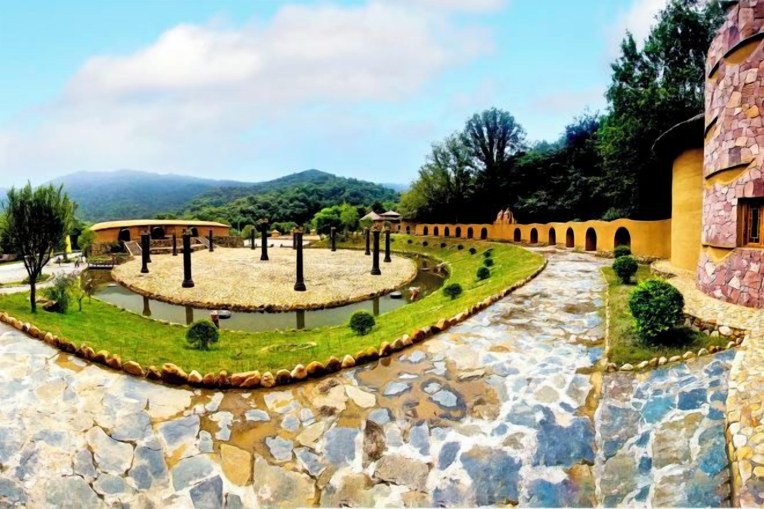 A courtyard with a stone pathway, a circular garden, and a building with arches.
