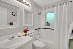 Un baño moderno con lavamanos, inodoro y bañera.