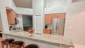 A modern kitchen with a large island, bar stools, and a built-in oven. - Charming 3-bedroom Pet Friendly house in tranquil Riverview (Riverview)