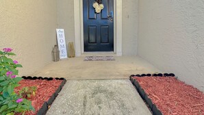 A front door with a wreath, a welcome mat, and a sign that reads "HOME". - Charming 3-bedroom Pet Friendly house in tranquil Riverview (Riverview)