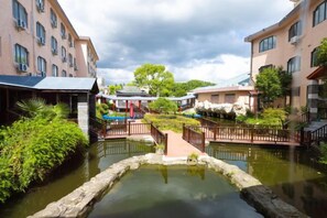 A courtyard with a water feature, surrounded by buildings with balconies and a covered seating area. - Kunshan Lushan Resort (Kunshan)
