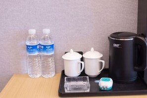 A tray with two water bottles, two white mugs, a black coffee maker, and a small electric toothbrush. - Kunshan Lushan Resort (Kunshan)