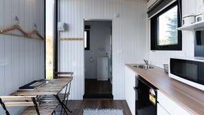 A compact kitchen with a wooden countertop, a sink, and a window above the sink. - Tussock Views by Tiny Away (Burkes Pass)