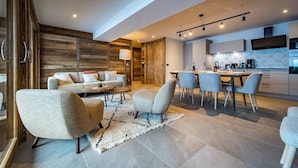 Un salon moderne comprenant un canapé, une table basse et un coin repas avec des chaises.