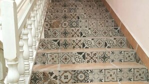 Un escalier orné de carreaux décoratifs et à motifs, avec des balustrades blanches.