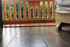 A room with a balcony, a tiled floor, and a sign in a foreign language. - Yangshuo Huayuan Hotel (20 yuan Renminbi Scenic Area) (Yangshuo)