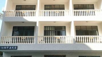 A multi-story building with balconies and a sign indicating it is a hospital.