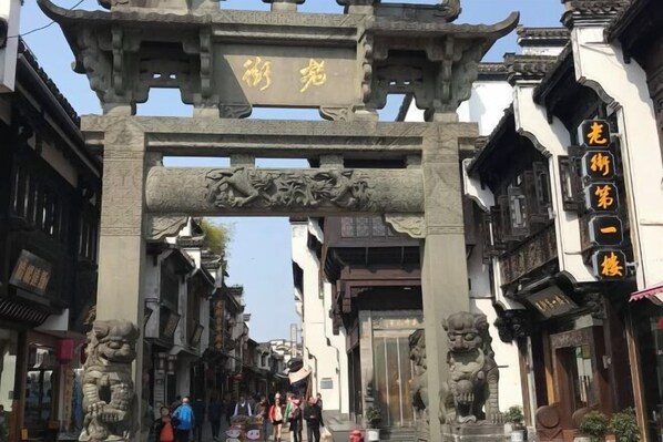 Um portão tradicional chinês com esculturas detalhadas e uma placa.