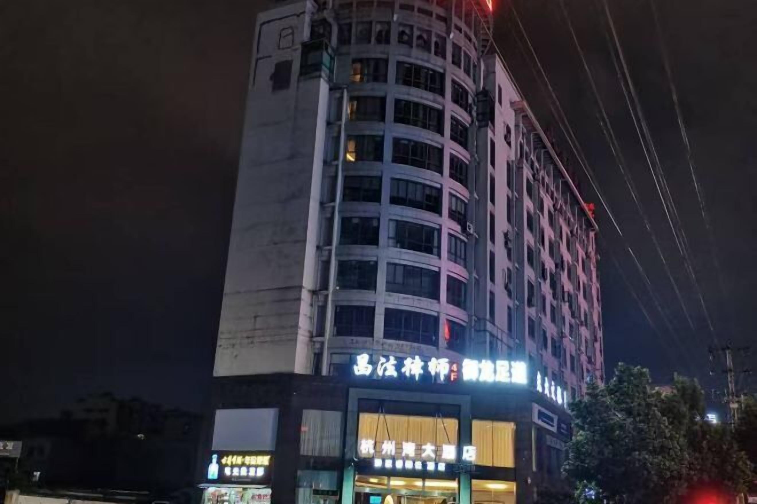 Un edificio a più piani con insegne illuminate, tra cui una ben visibile per un hotel e un ristorante.