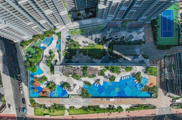 A high-rise residential building with a rooftop pool, landscaped terraces, and a tennis court. - Lumiere riverside - Apartment Raymond Holm (Ho Chi Minh City)