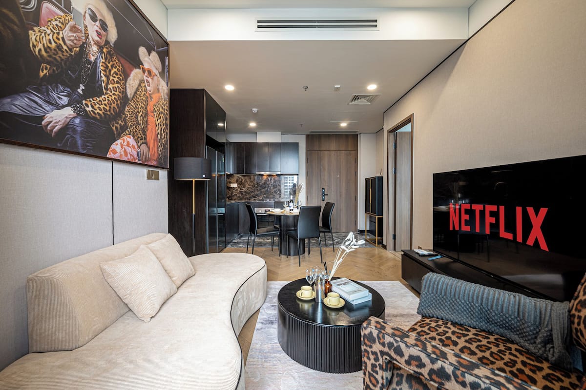 Panorama tweepersoonskamer, 2 slaapkamers | Woonruimte | Een 65-inch flatscreentelevisie met satellietzenders en Netflix