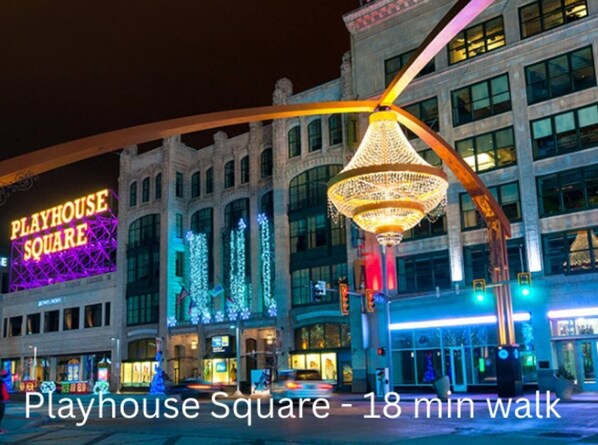 En väl upplyst byggnad i Playhouse Square, med en neonreklamskylt, dekorativa lampor och en stor, utsmyckad lampa.