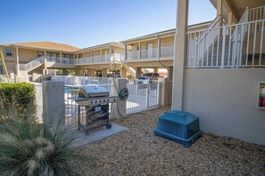 Enjoy a refreshing dip in the pool surrounded by an outdoor space with a barbecue grill and seating area.