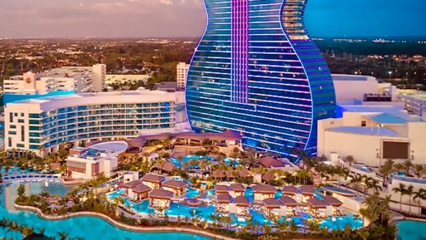 A resort with a large pool area, multiple buildings, and a distinctive guitar-shaped structure.