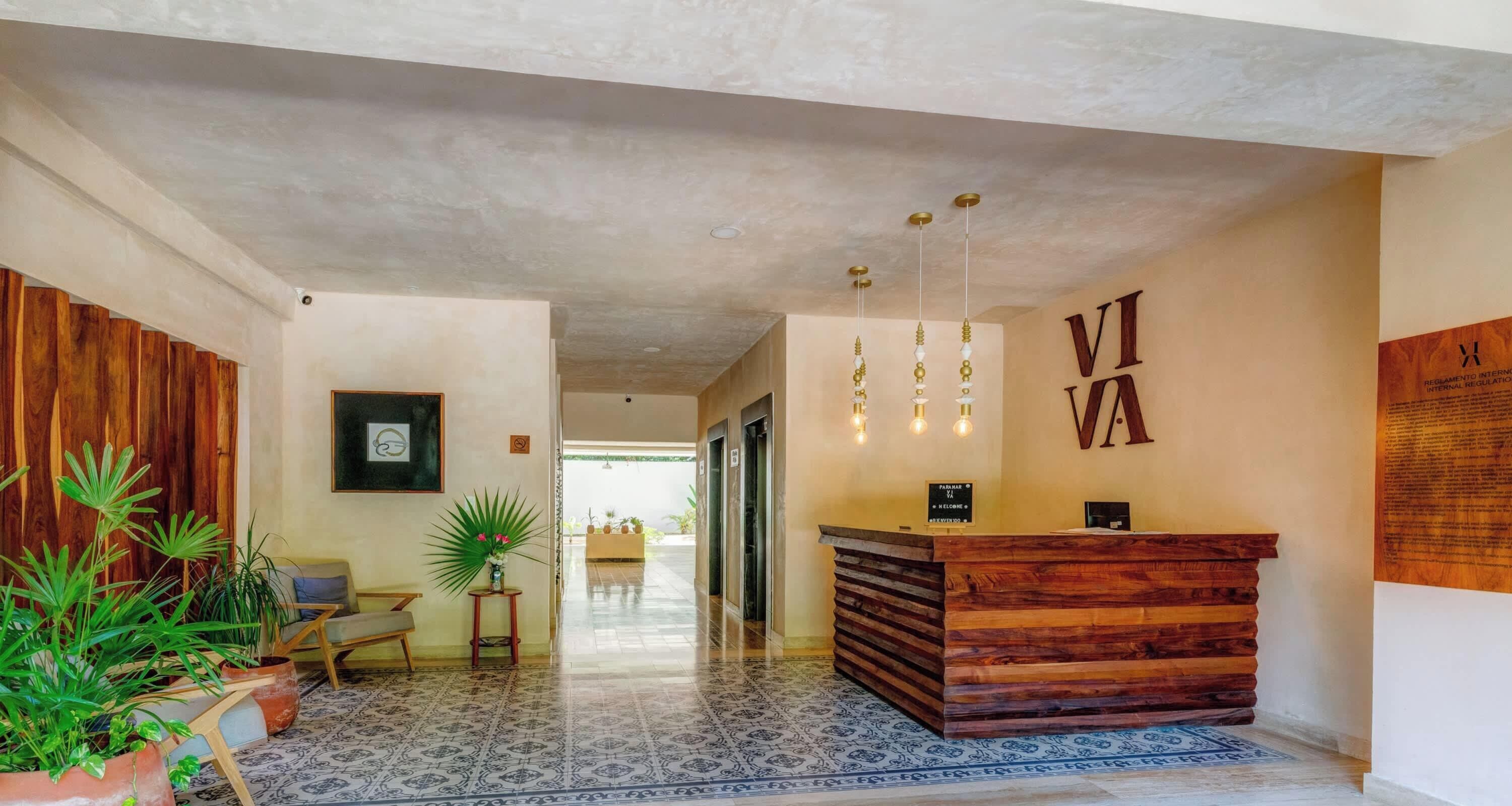 A reception area with a wooden reception desk, a sign with 'VIAVA' on the wall, and a hallway leading to elevators.
