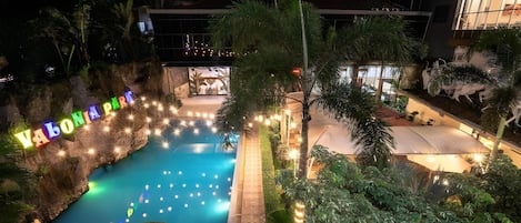 A nighttime view of a pool area with a sign reading 'VALONIA PARK' and surrounding greenery.