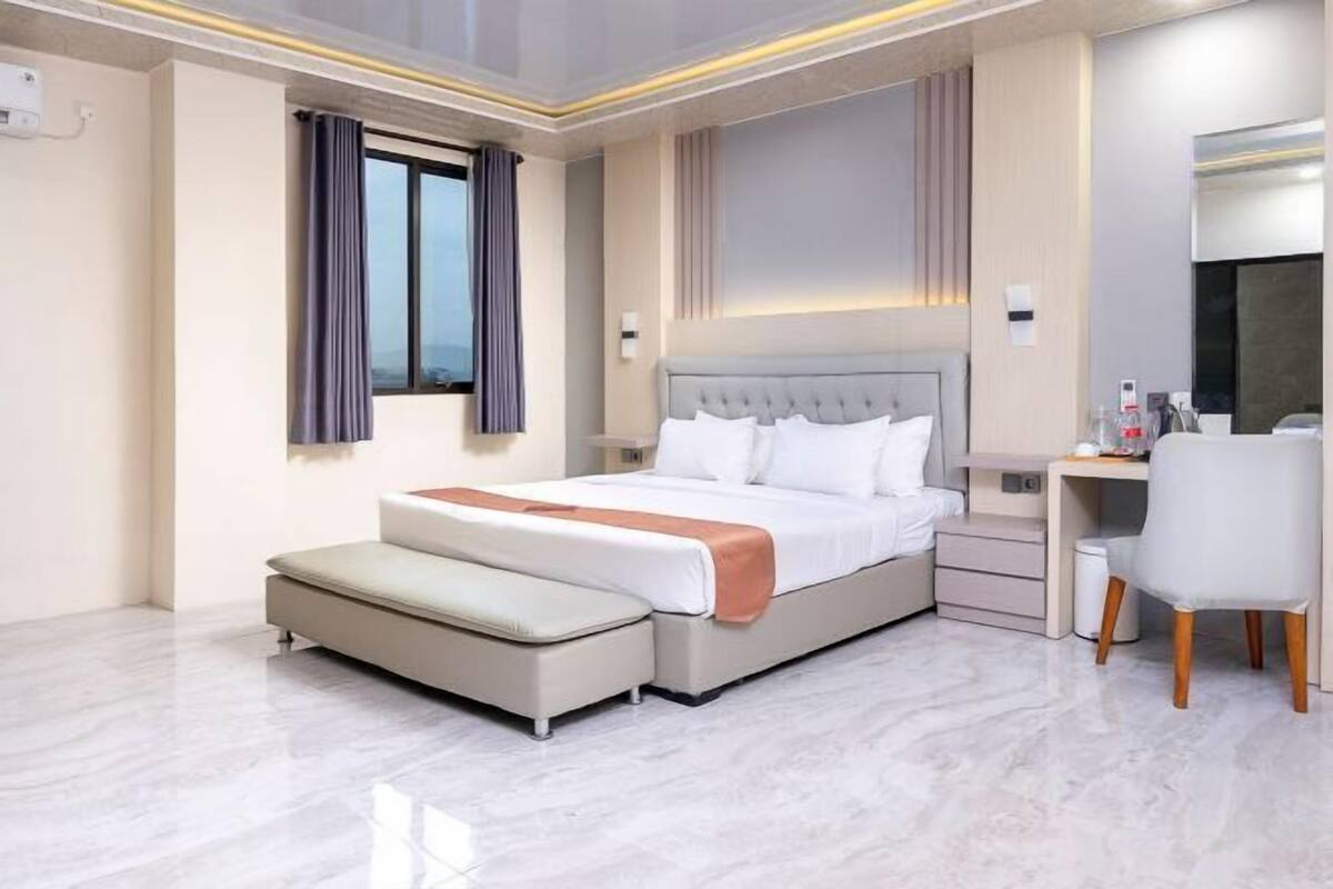 Une chambre d’hôtel moderne, dotée d’un grand lit, d’un bureau et d’une chaise.