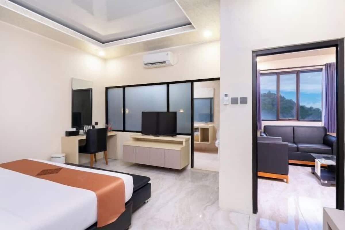 Une chambre d’hôtel moderne équipée d’un lit, d’un bureau, d’une télévision et d’un canapé.