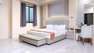 A modern hotel room with a bed, a desk, and a chair.