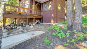 A wooden cabin with a balcony, surrounded by trees and a dirt ground. - Deck w/ Mountain Views: Cabin in Bear Valley! (Bear Valley)