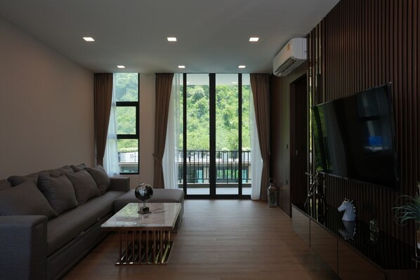 A modern living room with a sofa, a coffee table, and a TV mounted on the wall.