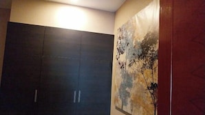 A room with a dark wooden wardrobe and a large abstract painting on the wall. - Berich Poolvilla Pattaya (Pattaya)