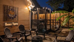 A patio area with outdoor seating, a fire pit, and a wooden fence.